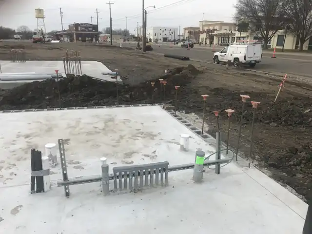 Depot Green Muskogee slab with conduit stub-ups, the branded Moore Electric and Logistics truck, downtown Muskogee behind