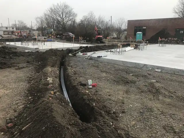 A bored conduit run in an open trench between two poured slabs at Depot Green Muskogee