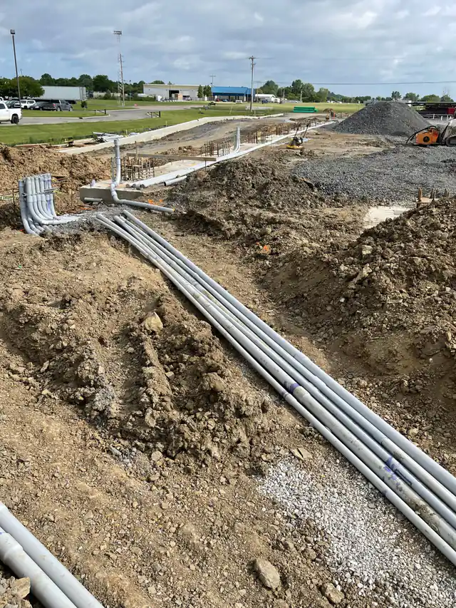 A long PVC duct bank in trench with a stub-up elbow bank at a pad