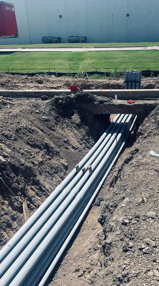 Duct bank running under a poured walk into a boxed trench