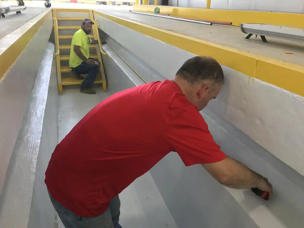 Two Moore Electric and Logistics electricians working in a coated equipment pit